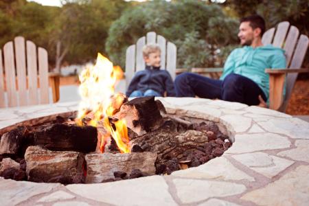 father and son sitting by firepit